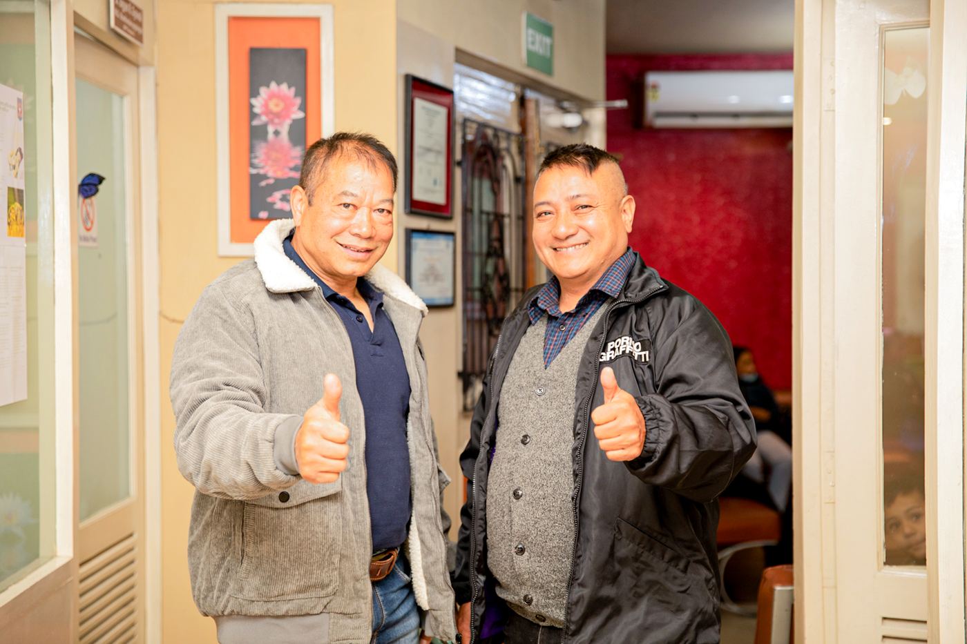 Two patients giving a thumbs-up at APC